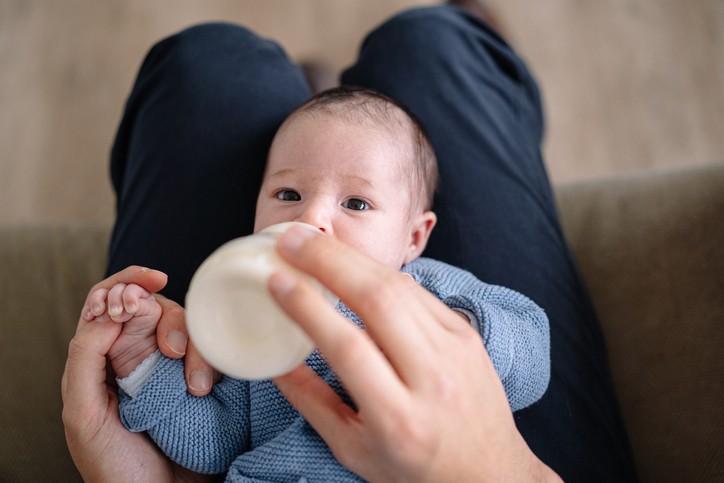 Photo shows newborn baby drinking milk from a bottle