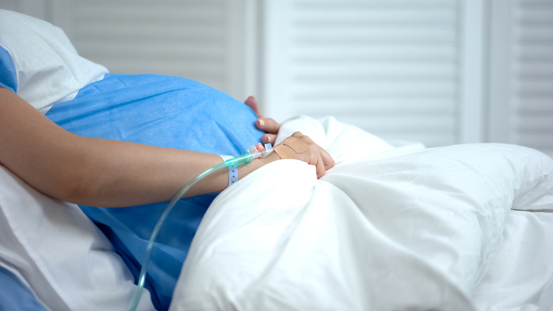 Photo shows pregnant woman laying in hospital bed