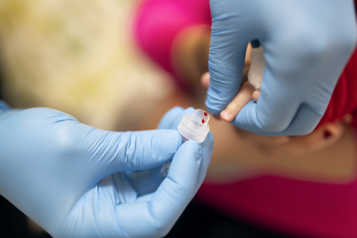 Photo shows doctor performing a blood test on an infant