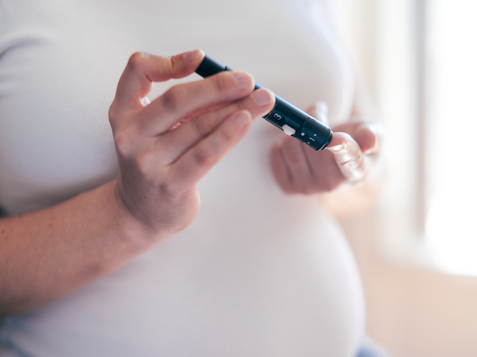 Photo shows pregnant woman testing her blood sugar