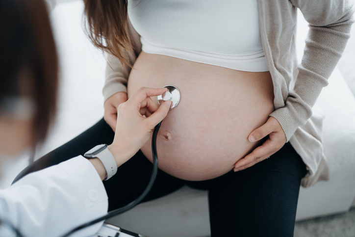 Photo shows doctor examining pregnant patient