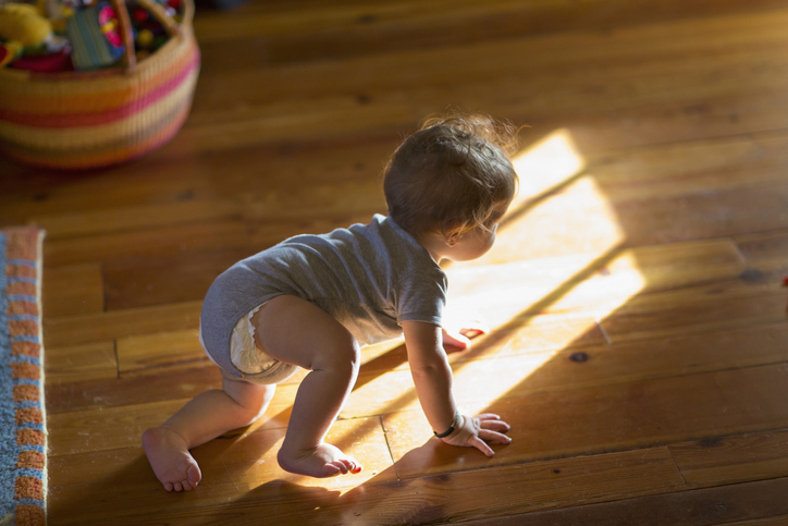 Photo shows baby crawling on the floor/Getty Images