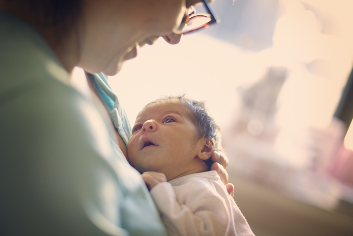 Photo shows a mother smiling at her newborn baby/Getty Images