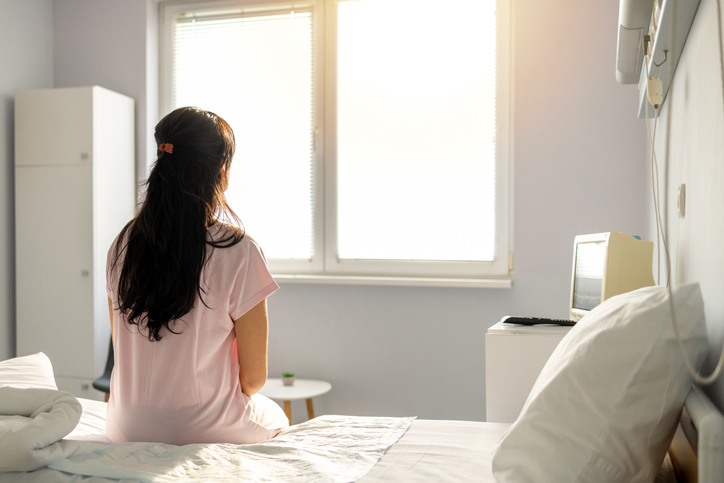 Photo shows a woman sitting in a hospital bed/Getty Images