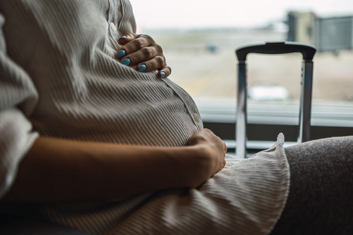 Photo shows a close-up of pregnant woman at the airport/Getty Images