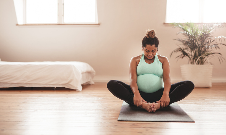 Photo shows a pregnant woman doing yoga at home/Getty Images