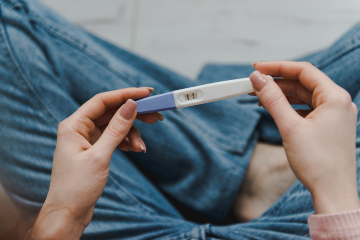 Photo shows a woman holding a positive pregnancy test/Getty Images