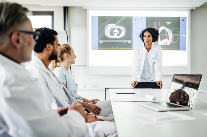 Photo shows a group of doctors discussing research data together in the hospital/Getty Images