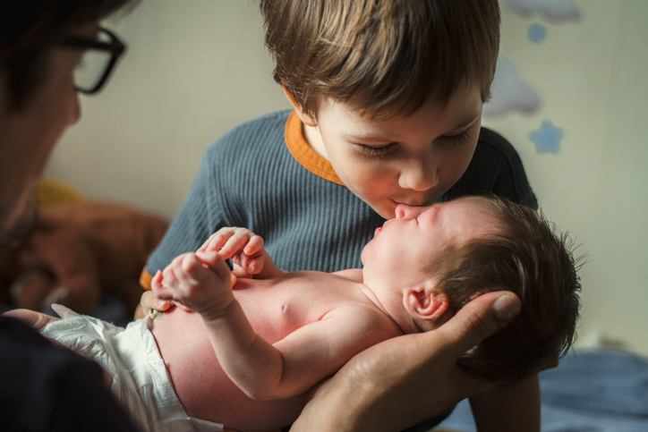 Photo shows a little boy kissing his newborn sister/Getty Images