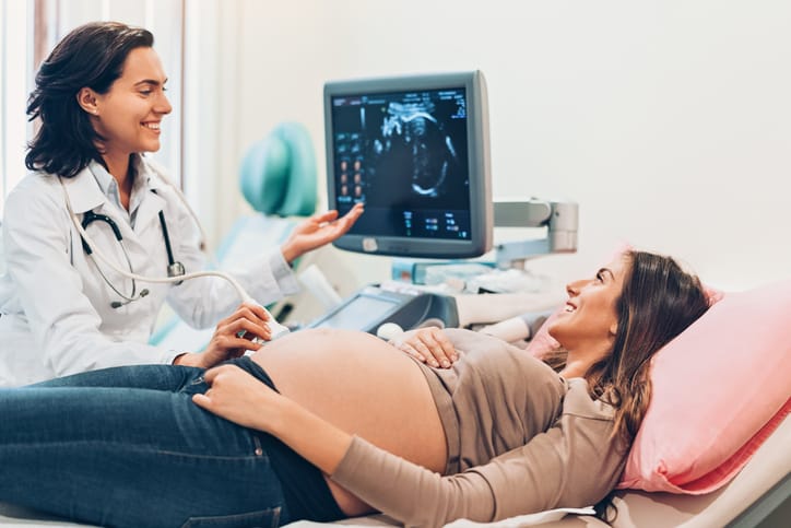 Photo shows a pregnant woman looking at her baby on an ultrasound/Getty Images