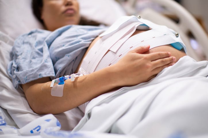 Photo shows a pregnant woman in the hospital with a iv drip and a cardiograph/Getty Images