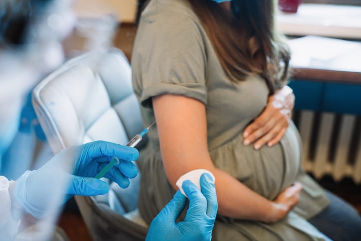 Photo shows a doctor giving a pregnant woman an injection/Getty Images