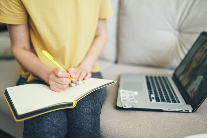Photo shows a woman taking notes on medications and treatments/Getty Images