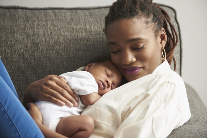 Photo shows a mother holding her sleeping infant/Getty Images