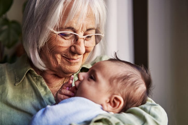 A grandmother holds her newborn grandchild/Getty Images
