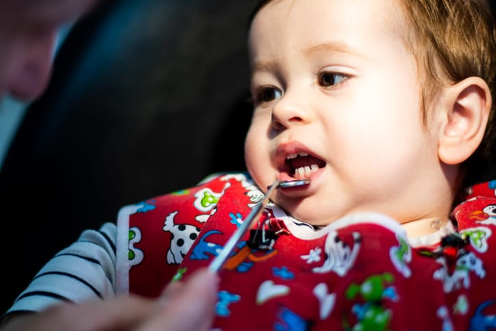 Photo shows a pediatric dentist examining a child's teeth/Getty Images