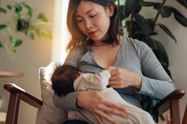 Photo shows a mother breastfeeding her newborn while sitting at home/Getty Images