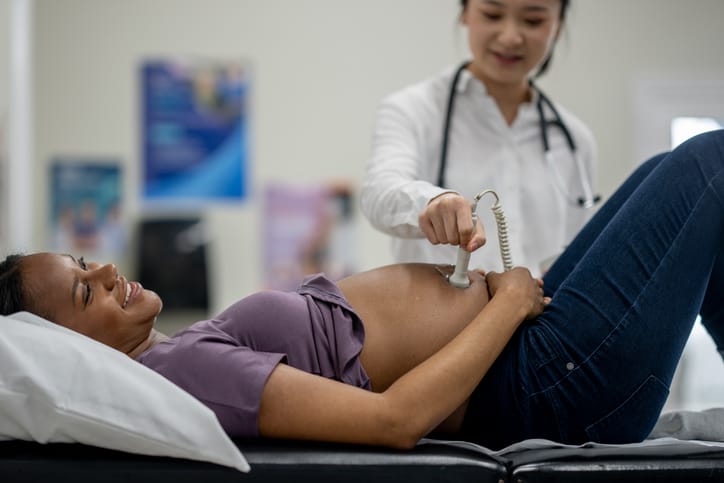 Photo shows a physician performing an ultrasound examination on a pregnant woman (Getty Images/FatCamera)