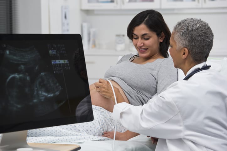 Photo shows a doctor performing an ultrasound on a pregnant patient/Getty Images