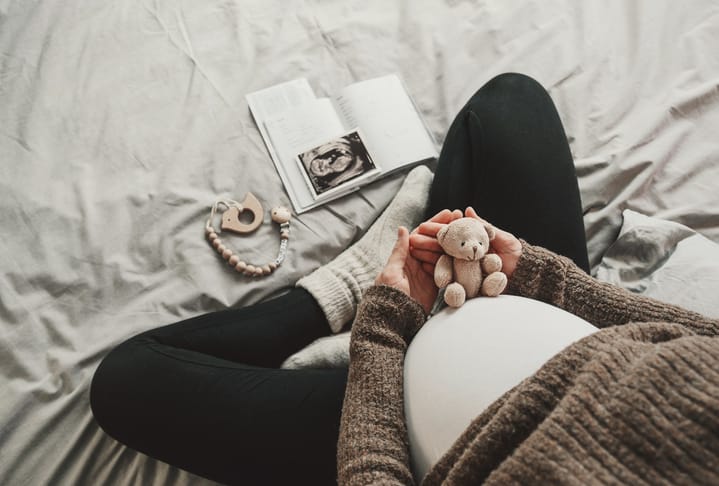 Photo shows a pregnant woman looking at items related to her unborn child/Getty Images
